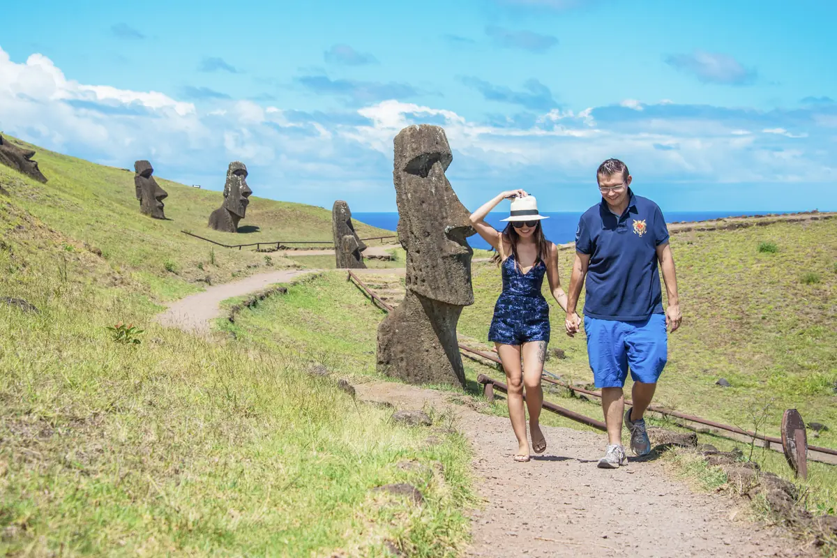 Two travelers walking among the moai on the slopes of Rano Raraku, Easter Island